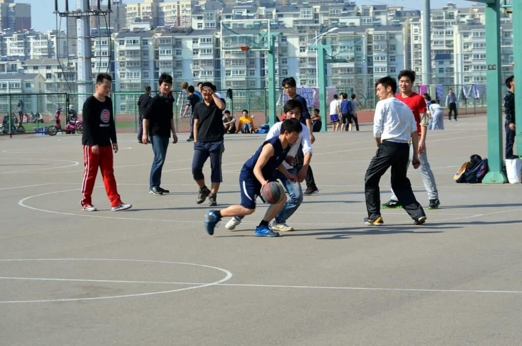 야외 농구장에서 한 선수가 드리블하는 모습